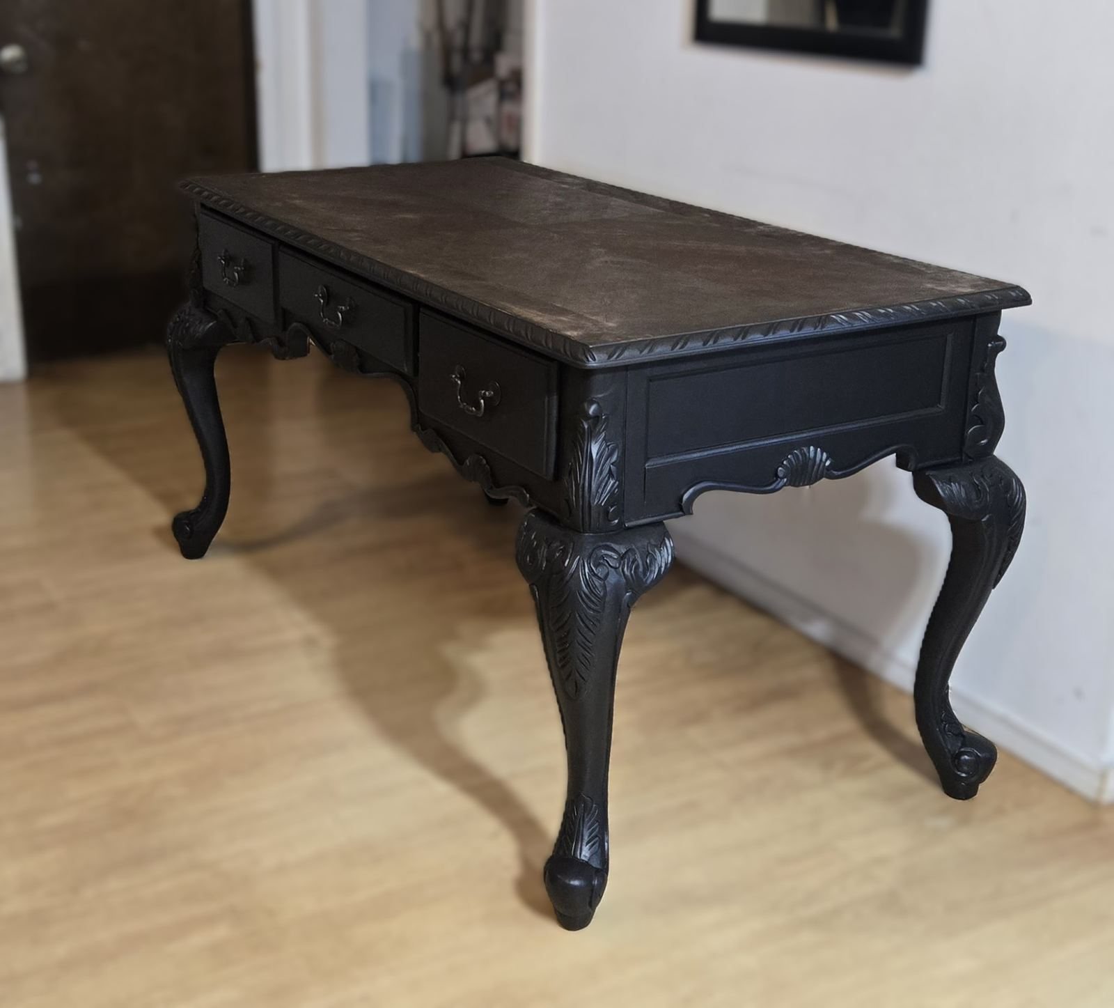 Black carved desk finished in a dark painted statement finish