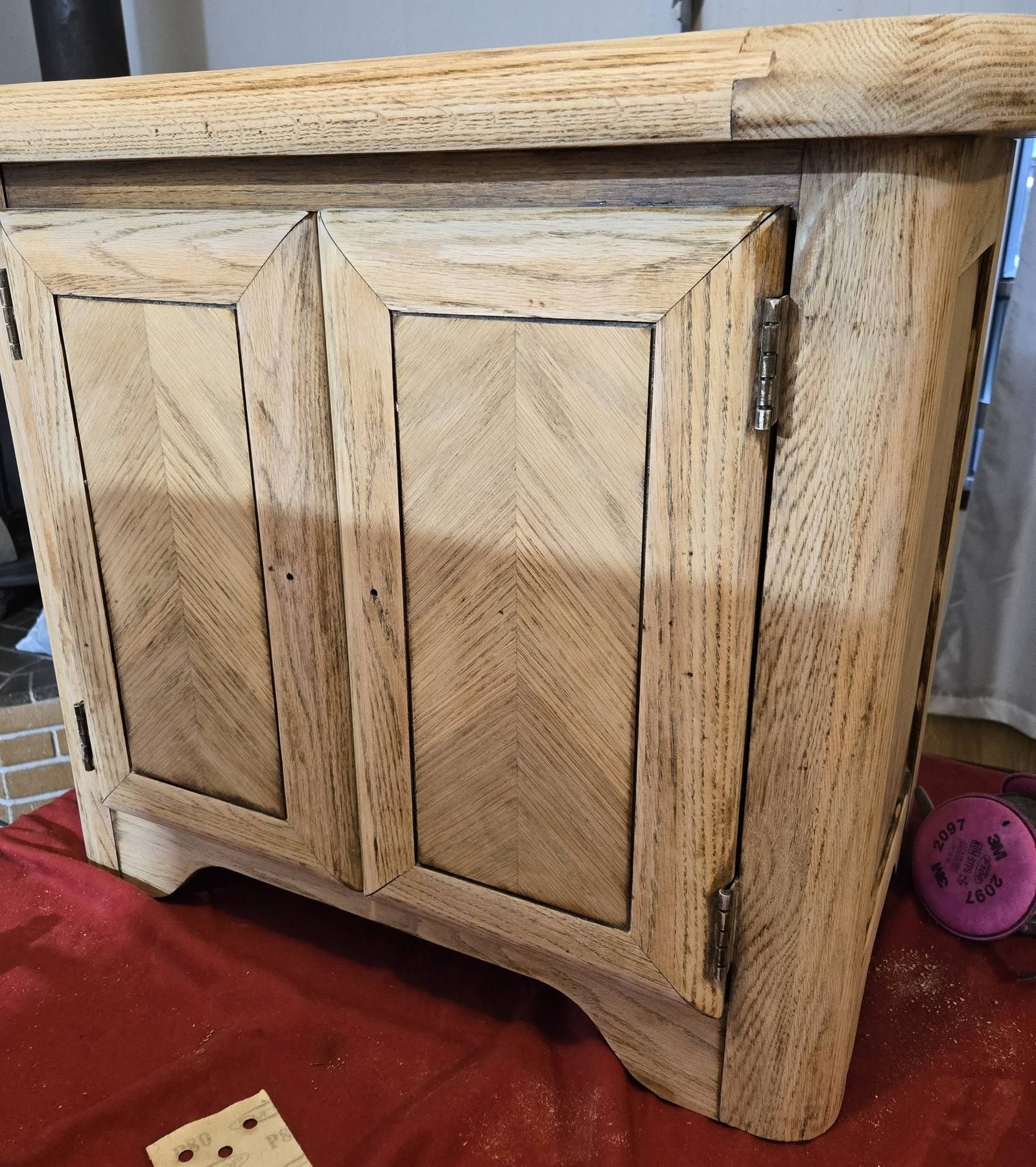 Close-up of carved oak nightstand wood grain and cabinet door detail during refinishing