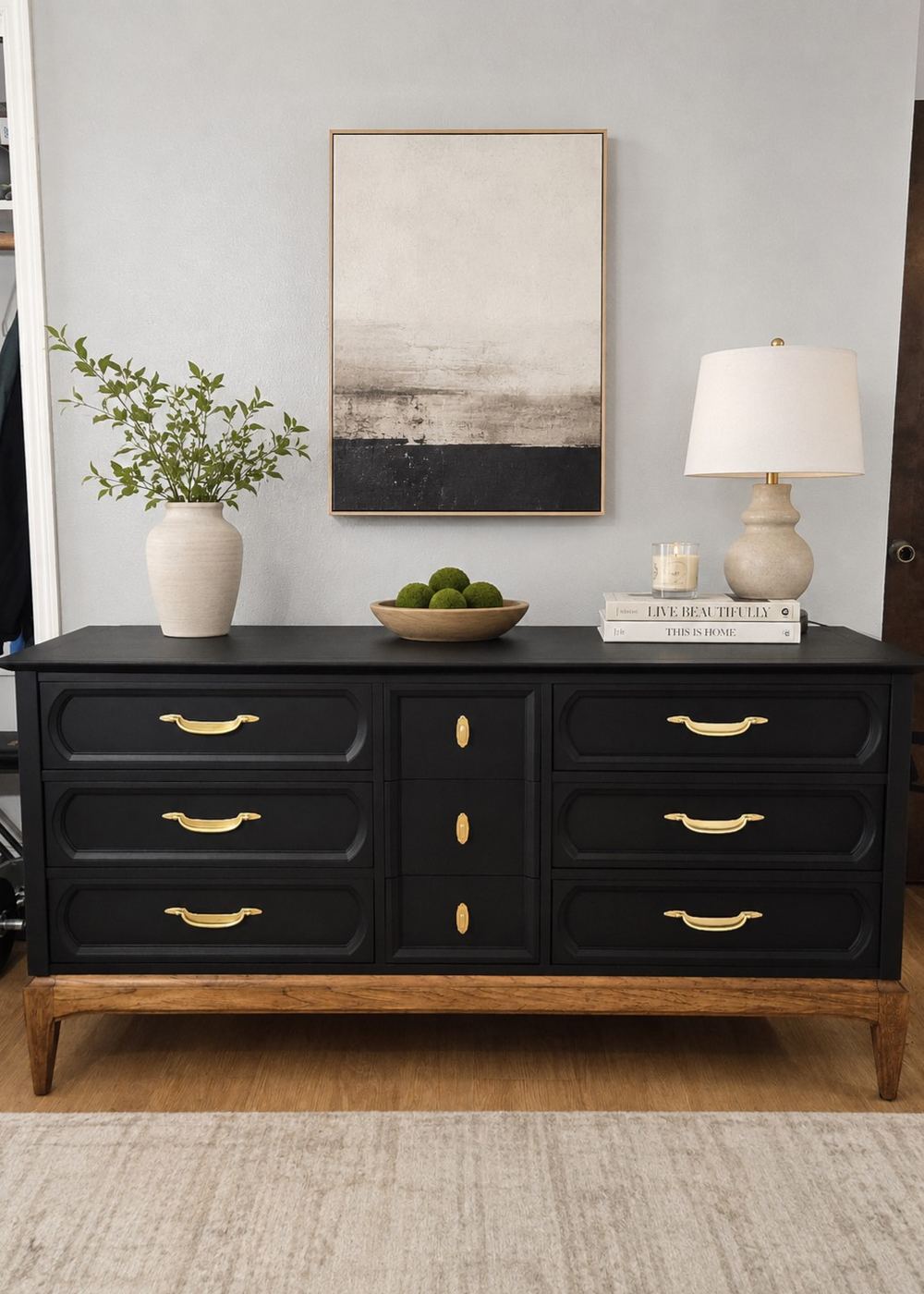 Satin black long dresser after restoration with warm wood base and brass hardware