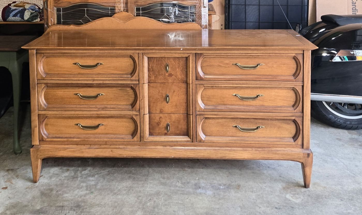 Long dresser before restoration with dated orange wood tone and original hardware