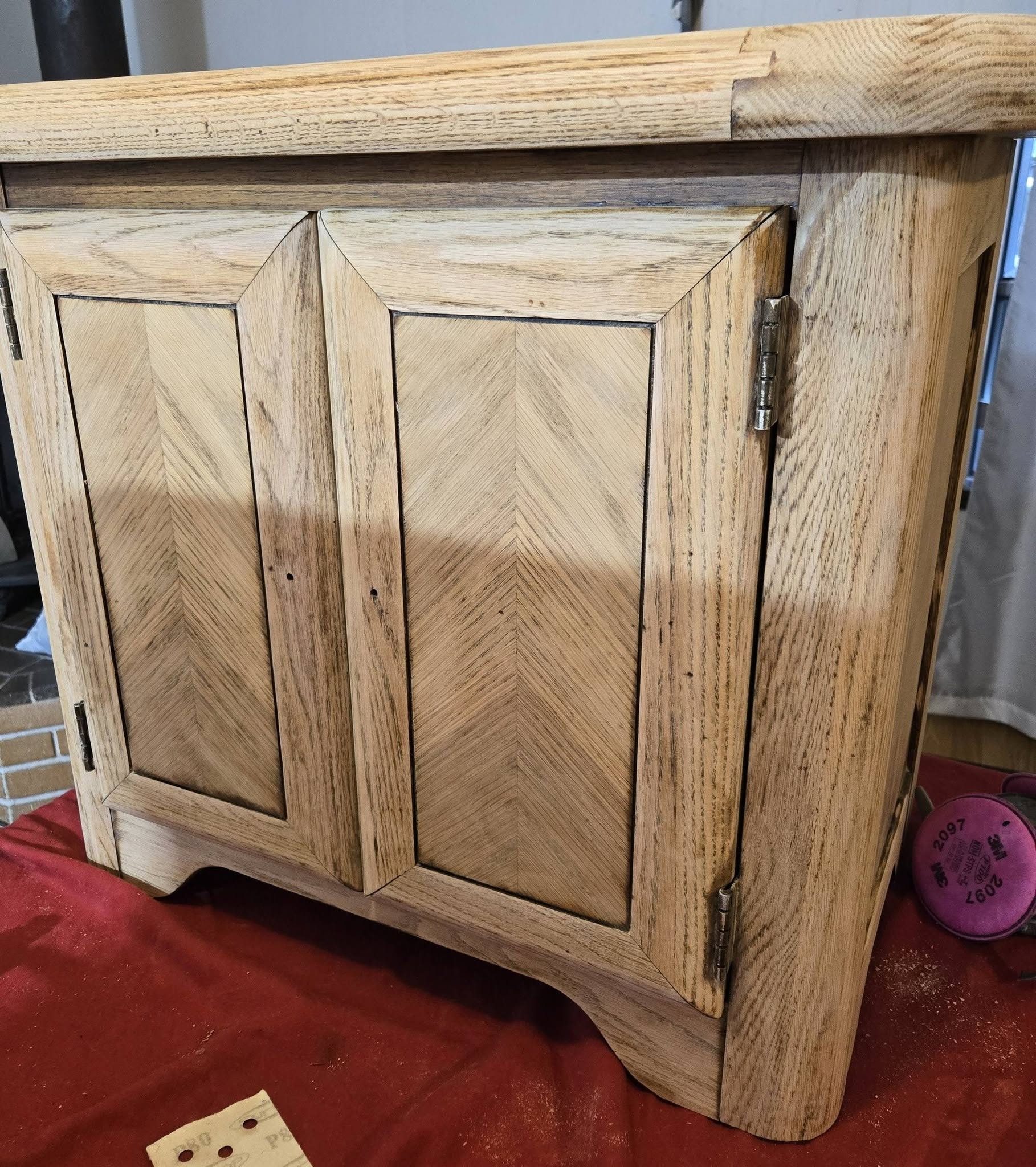 Oak console cabinet before restoration — stripped to bare wood showing beautiful chevron grain door panels, ready for dark stain, Tumwater WA