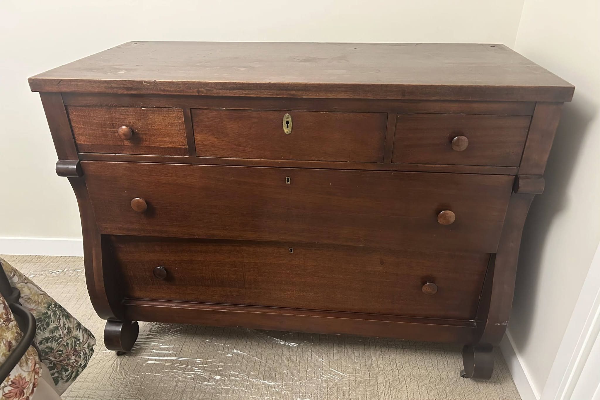 Antique Empire mahogany chest of drawers before restoration — dark worn surface, brass keyhole escutcheons, scroll foot base, circa 1840s, presented for refinishing in Olympia WA