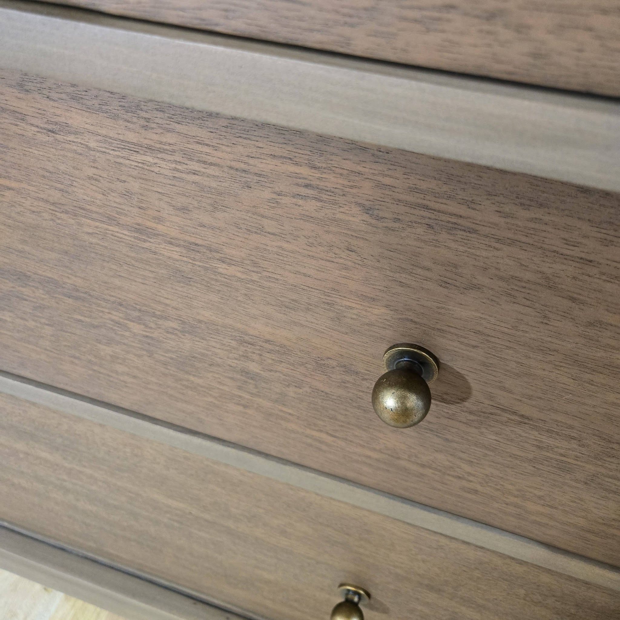 Close-up of aged brass dome knob on restored antique Empire dresser drawer — rich grain visible on mahogany surface after stain treatment, Broken Souls Restoration