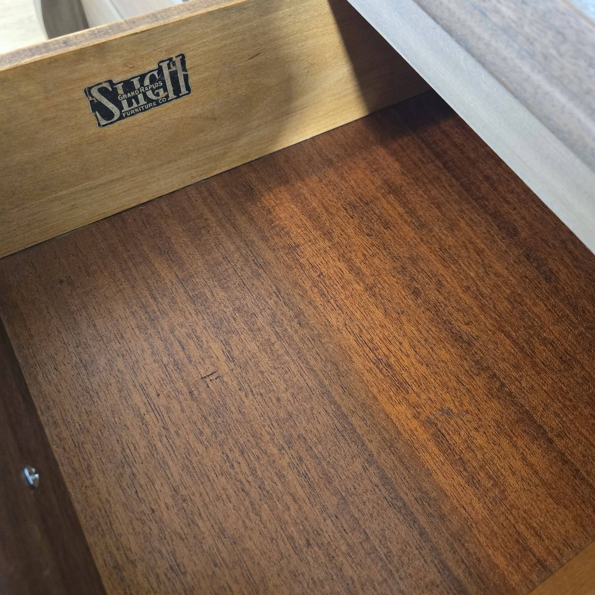 Sligh Furniture Co. Grand Rapids maker's label stamped on the interior drawer frame of the antique Empire dresser — original provenance marker preserved during restoration