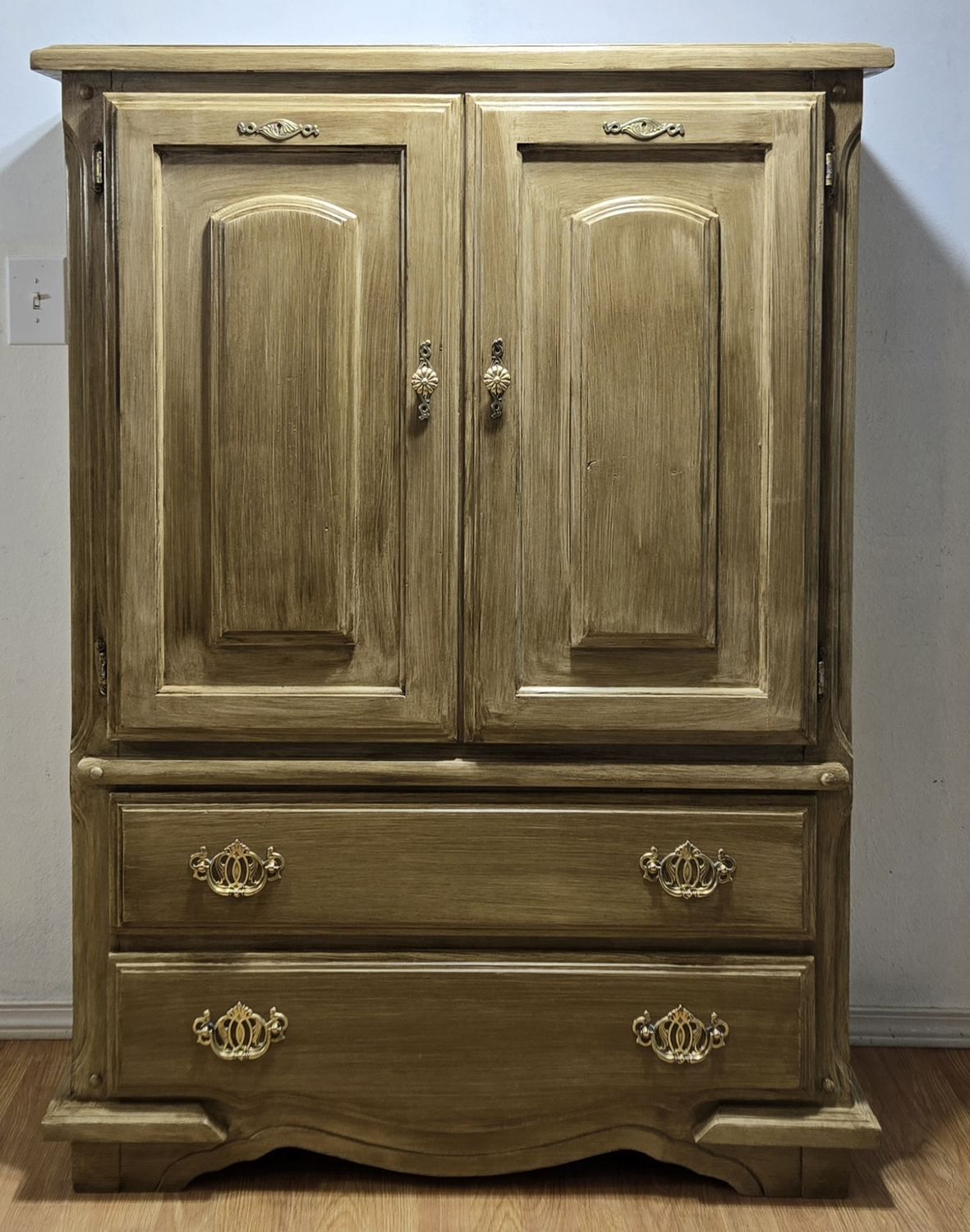 Tall cabinet with aged finish and ornate hardware